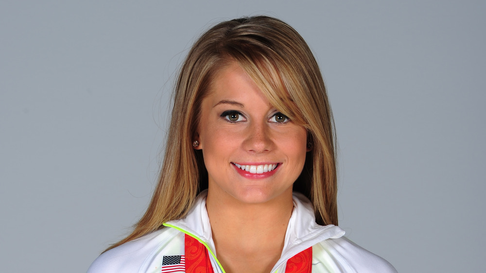 Shawn Johnson en una sesión de fotos con sus medallas