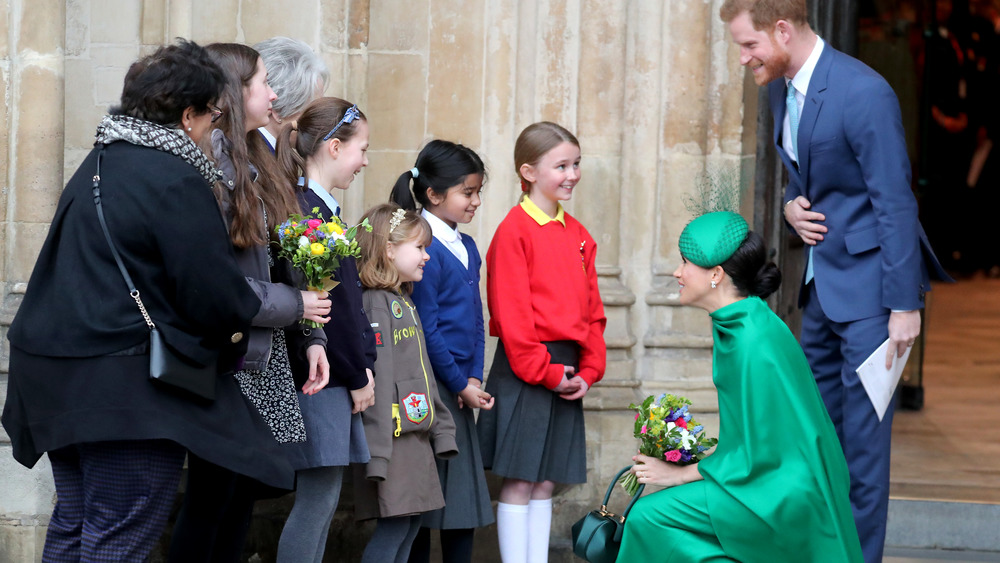 Meghan Markle y el príncipe Harry saludan a los niños