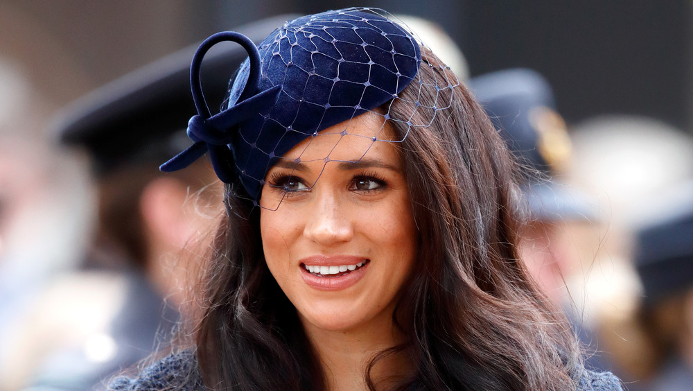 Meghan Markle, la duquesa de Sussex, sonriente y vestida de azul marino