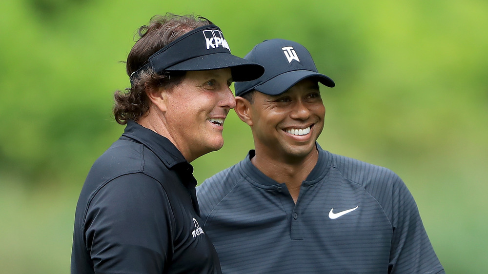 Phil Mickelson y Tiger Woods sonriendo juntos