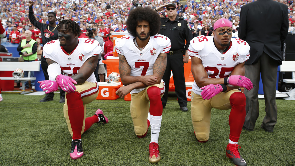 Eli Harold, Colin Kaepernick y Eric Reid se arrodillan en protesta