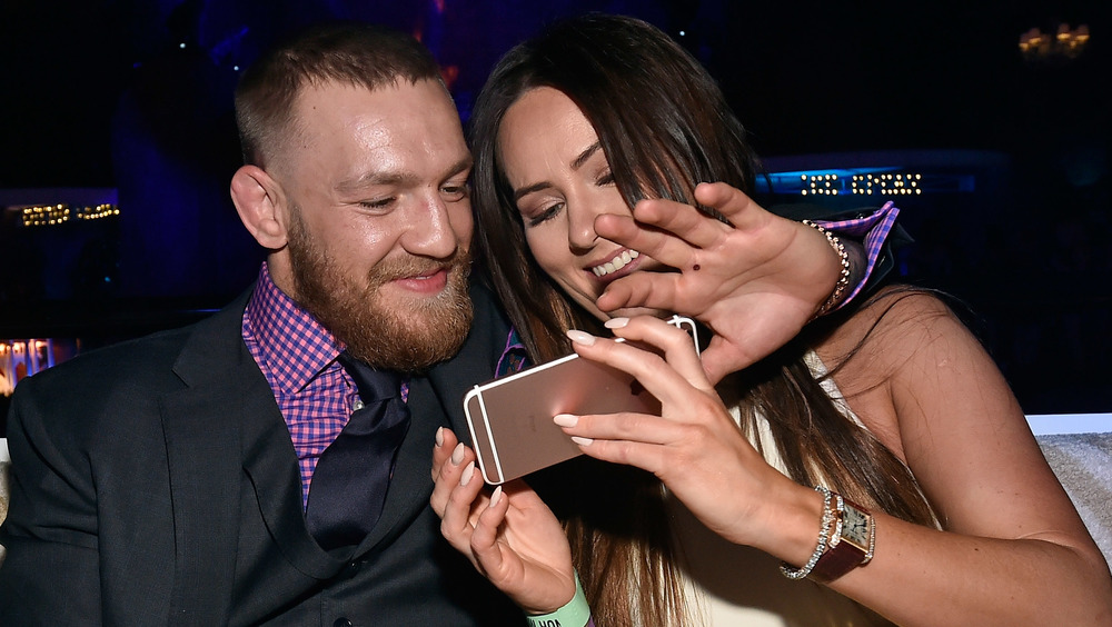 Connor McGregor y Dee Devlin miran su teléfono