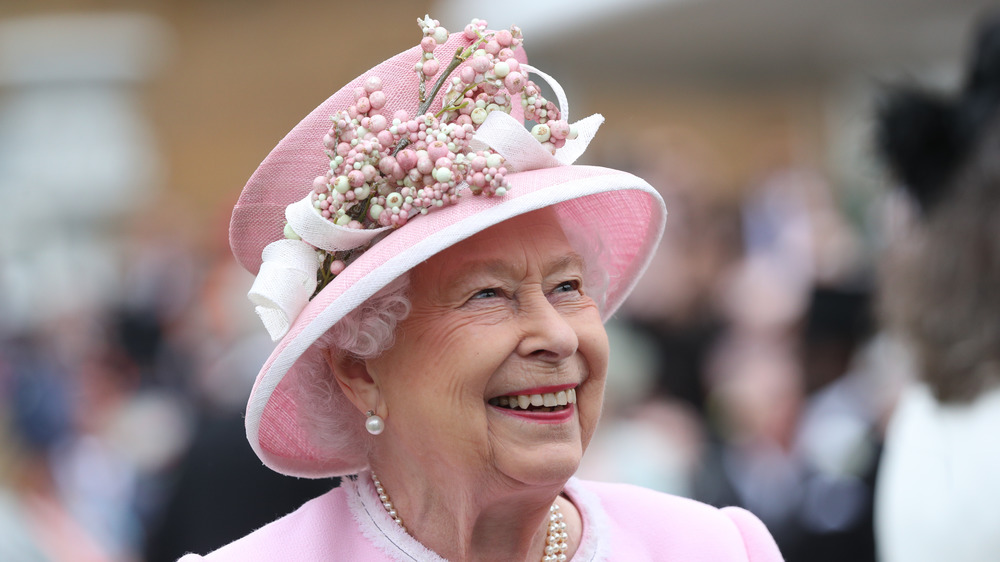 Queen Elizabeth sombrero rosa sonriendo