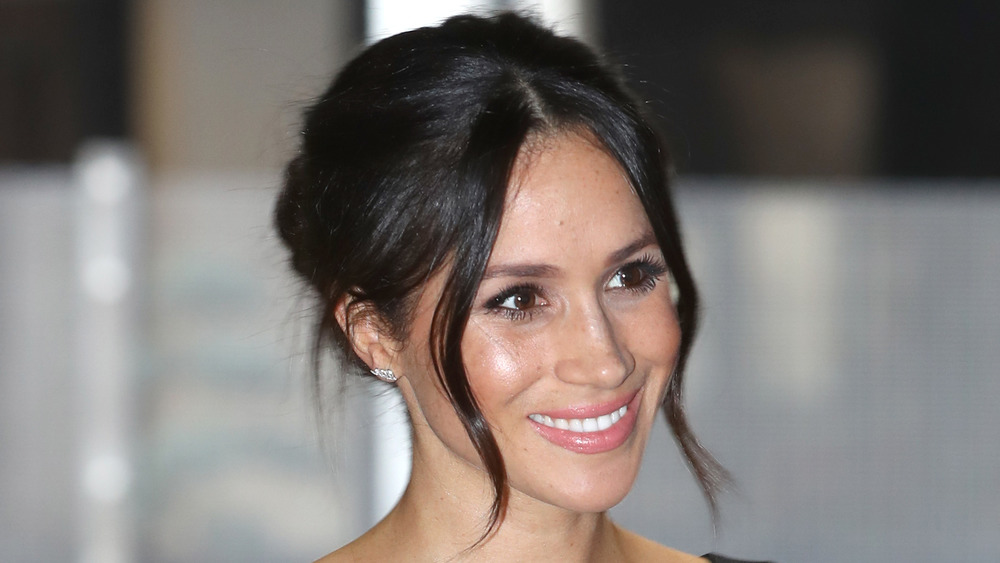 Meghan Markle sonriendo con el cabello recogido