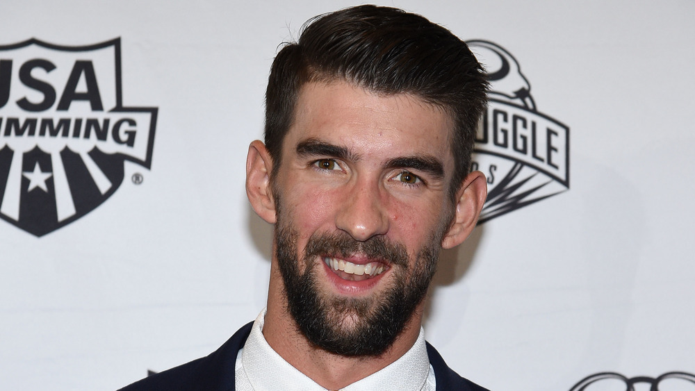 Michael Phelps sonriendo en la alfombra roja