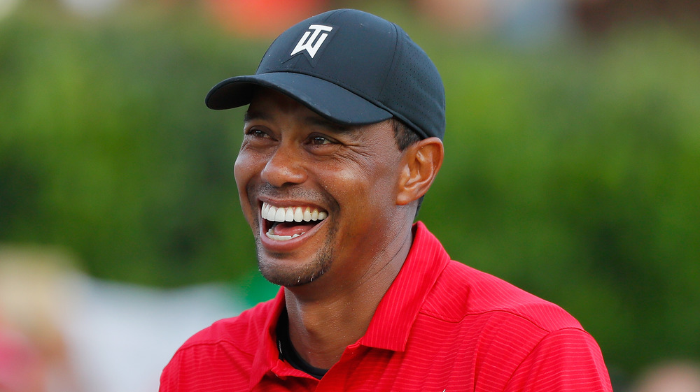 Tiger Woods con gorra de béisbol sonriendo 