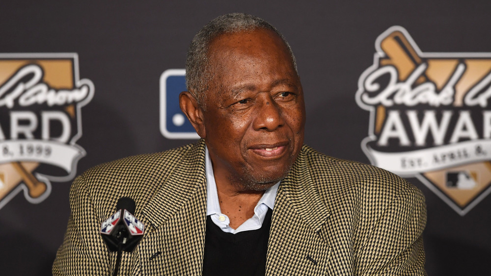 Hank Aaron sonriendo en una conferencia de prensa