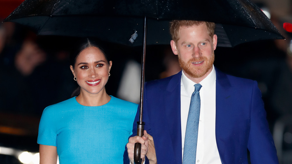 El príncipe Harry y Meghan Markle con paraguas