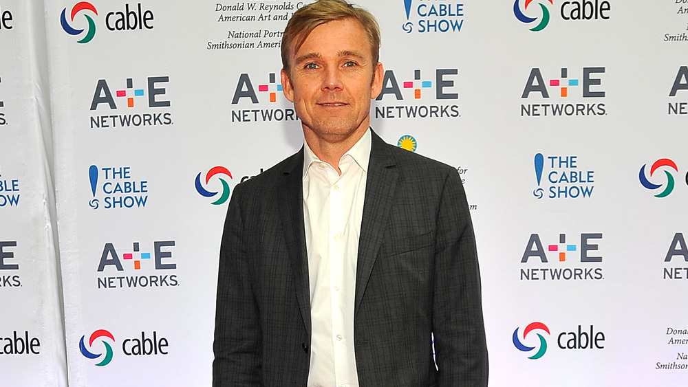 Ricky Schroder frente al muro promocional