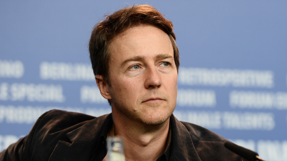 Edward Norton sentado en un panel