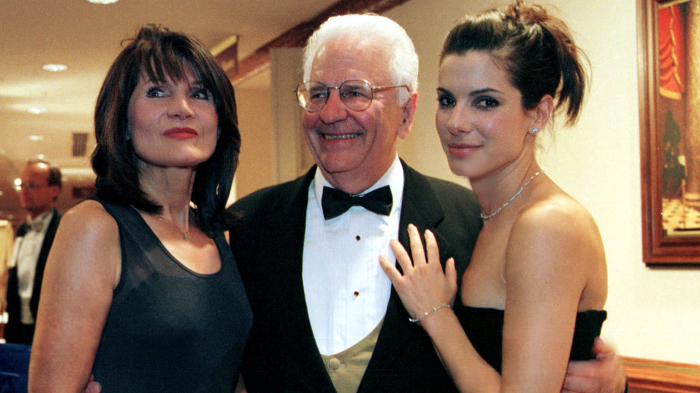 Sandra Bullock (extremo derecho) de pie junto a su padre y su madre