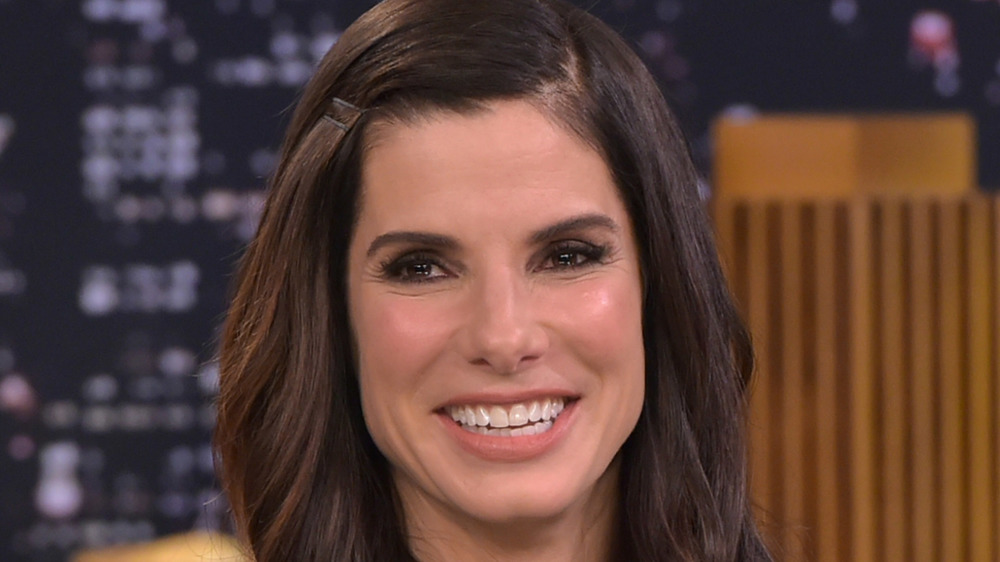 Sandra Bullock sentada en un sofá sonriendo