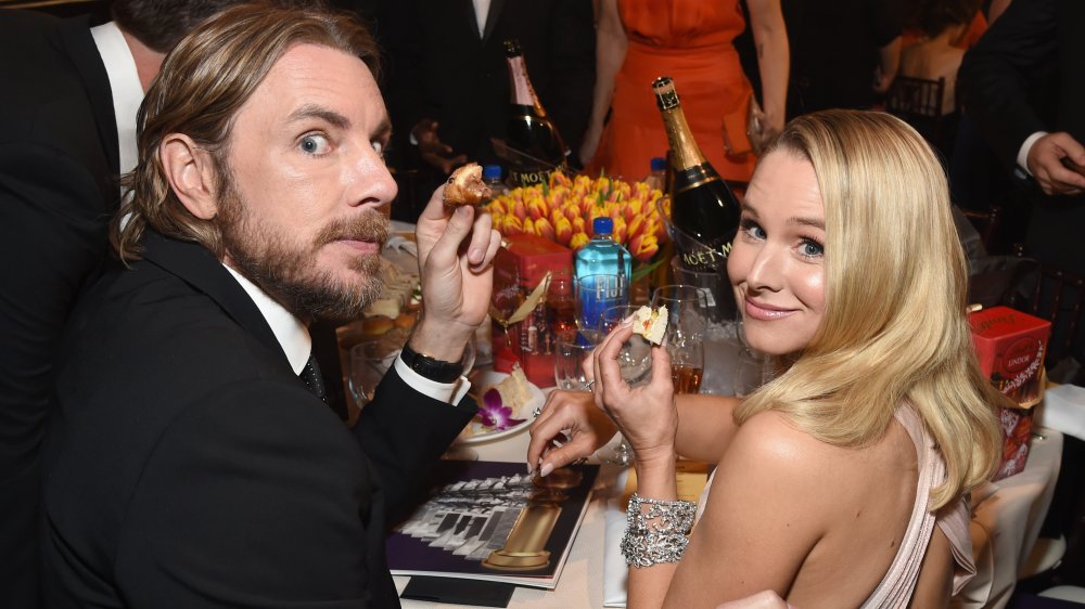 Dax Shepard y Kristen Bell en la mesa con comida del tamaño de un bocado en las manos