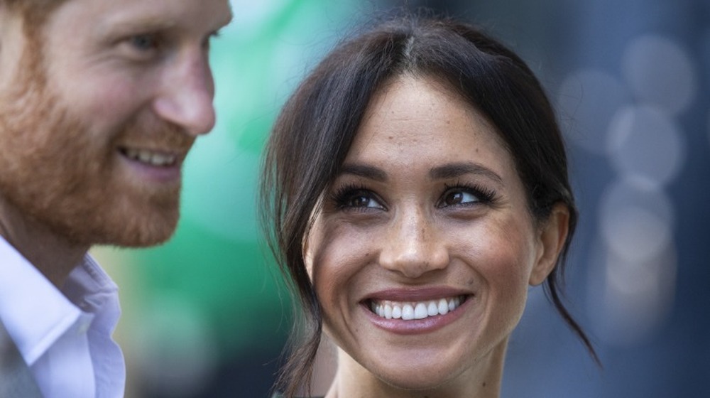 Meghan Markle mirando al príncipe Harry con amor en un evento