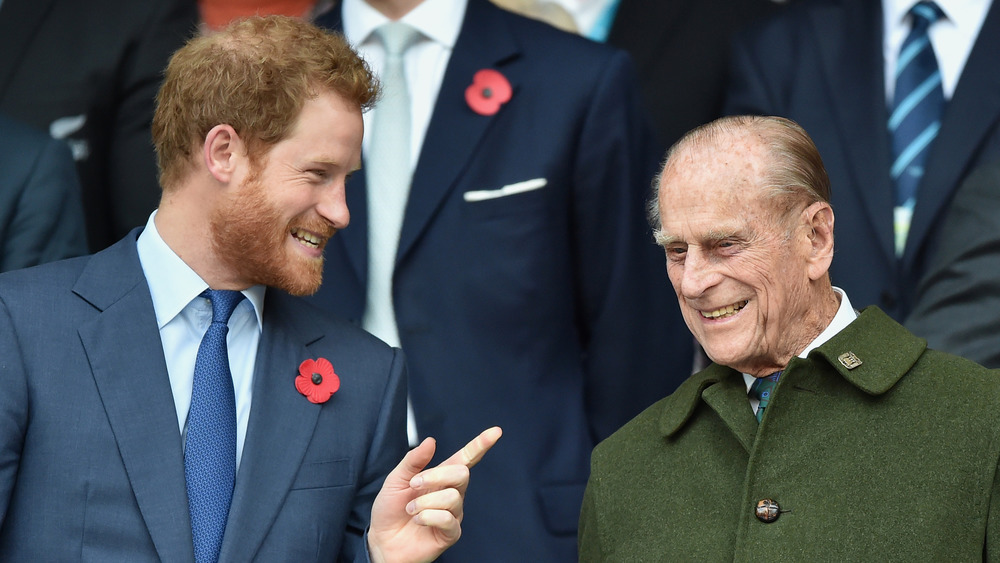 El príncipe Harry hablando con el príncipe Felipe 