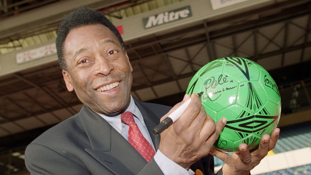 Pele firmando autógrafos en una pelota de fútbol