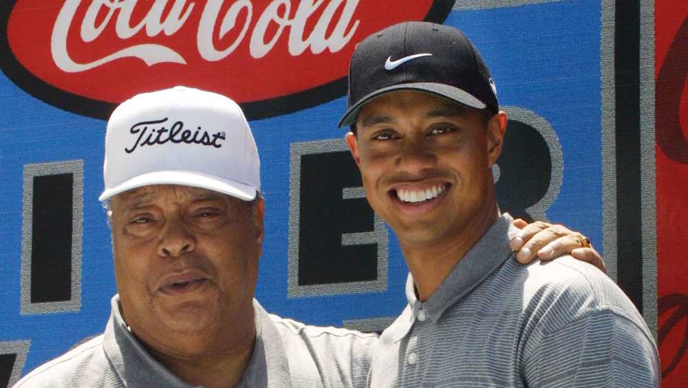 Tiger Woods y su padre Earl Woods posan durante un evento de la fundación de golf en 2001