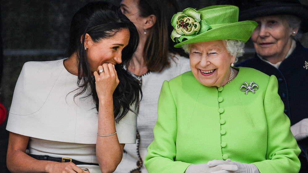 Meghan Markle, la reina Isabel, riendo