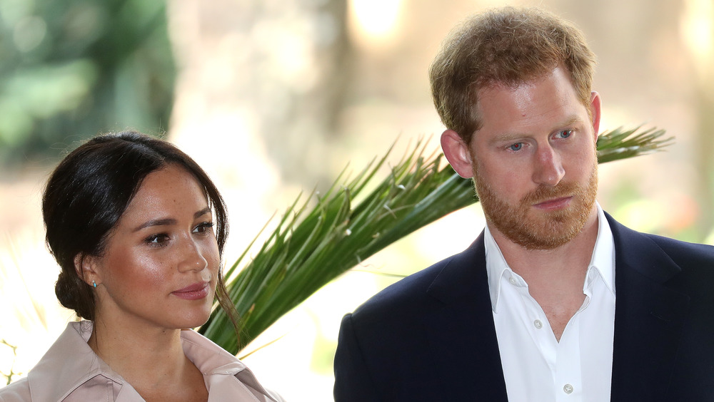 El príncipe Harry y Meghan Markle con expresiones serias