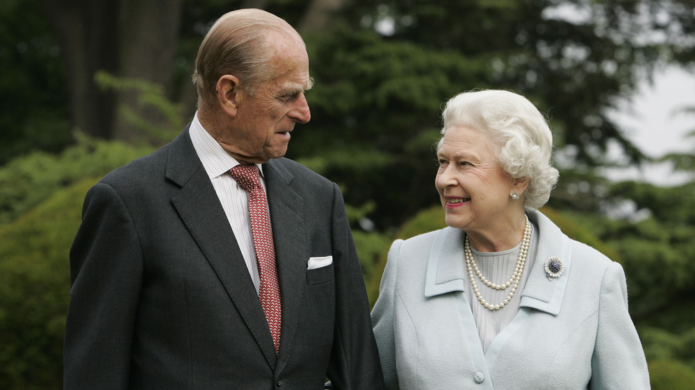 El príncipe Felipe y la reina Isabel II se sonríen el uno al otro 