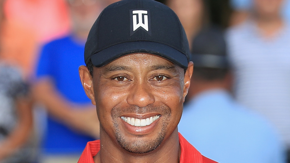 Tiger Woods sonriendo para fotos en el campo de golf