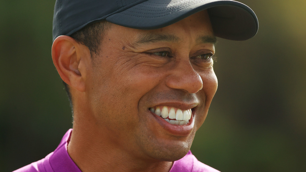 Tiger Woods sonriendo en el campo de golf