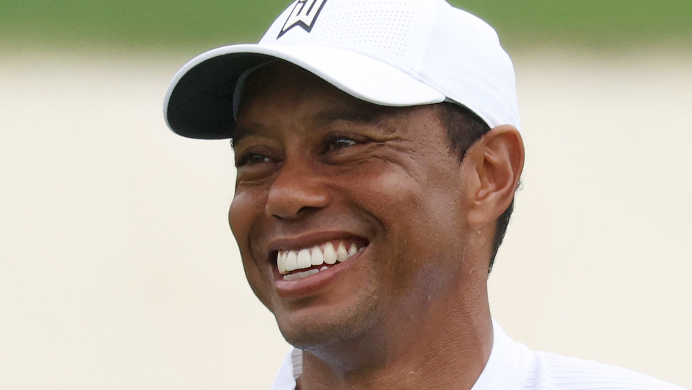 Tiger Woods sonríe en un campo de golf en 2020