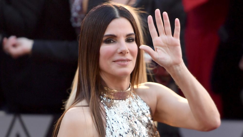 Sandra Bullock caminando y saludando en la alfombra roja