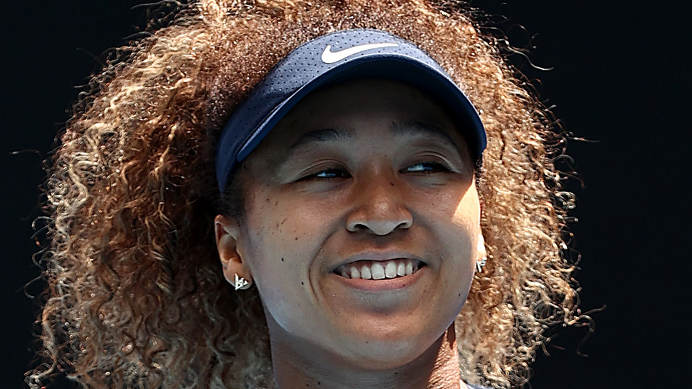 Naomi Osaka sonriendo después de ganar