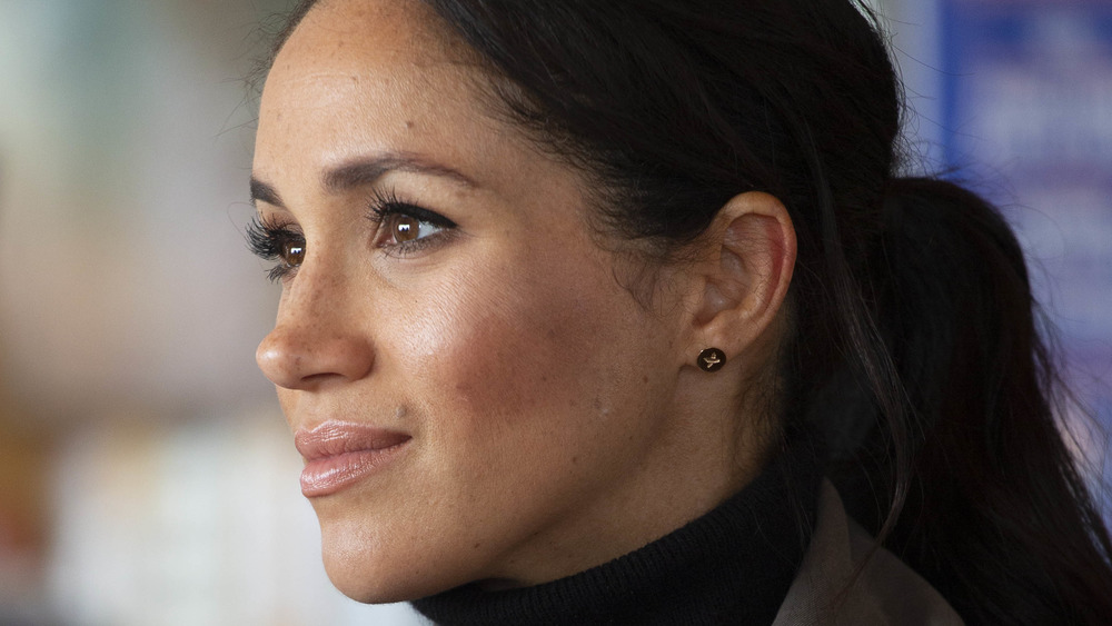 Meghan Markle mirando a lo lejos con una cola de caballo