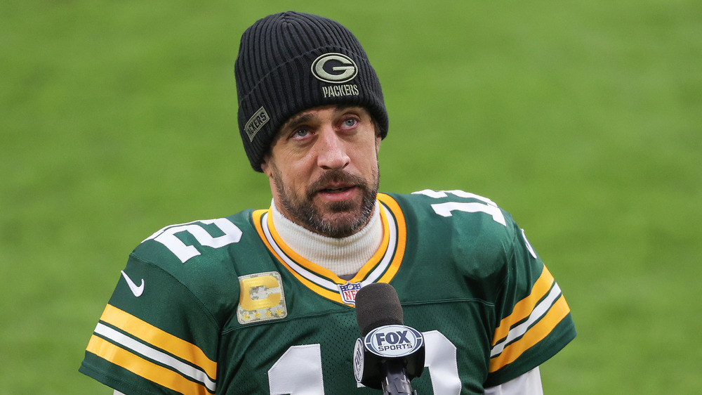 Aaron Rodgers usa gorra y camiseta de fútbol