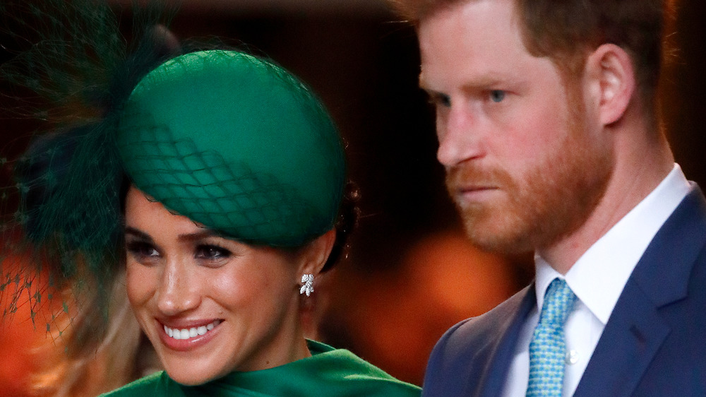 Meghan Markle con sombrero verde con el ceño fruncido Príncipe Harry