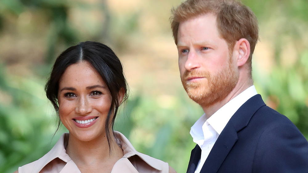 Meghan Markle y el príncipe Harry mirando hacia las cámaras