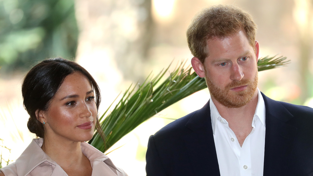 Meghan Markle y el príncipe Harry escuchan atentamente 