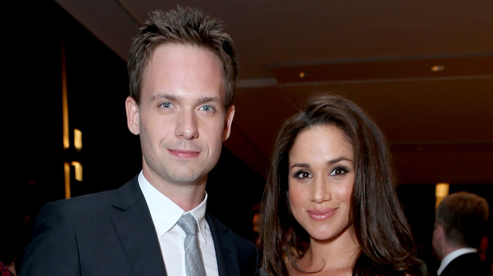 Patrick J. Adams y Meghan Markle sonriendo en un evento