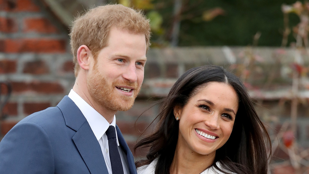 El príncipe Harry y Meghan Markle sonriendo para las cámaras