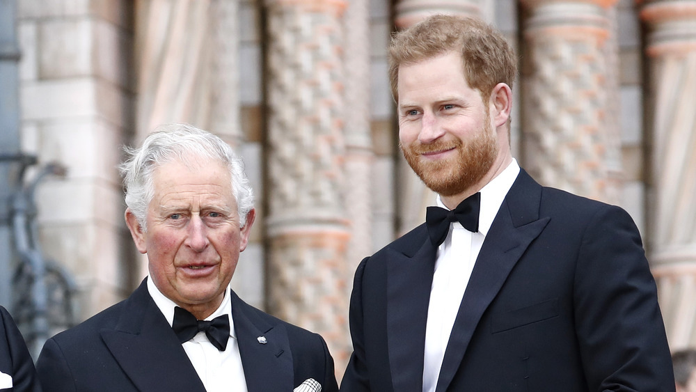 El príncipe Carlos y el príncipe Harry están uno al lado del otro en un evento 