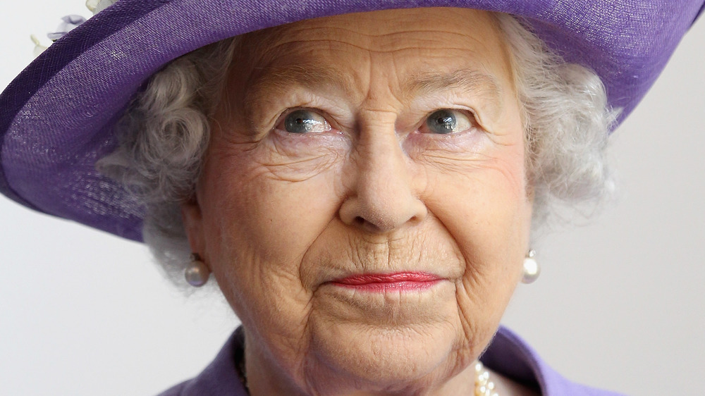 La reina Isabel con sombrero morado