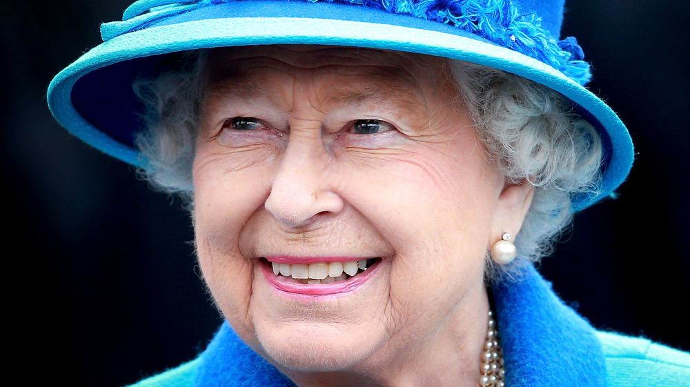 La reina Isabel II lleva un sombrero azul 