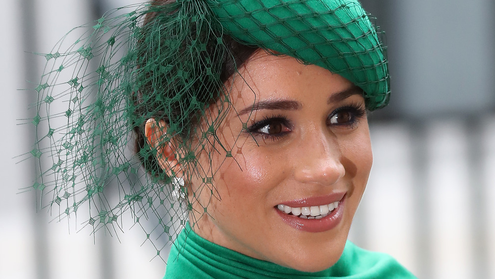 Meghan Markle sonriendo con sombrero verde