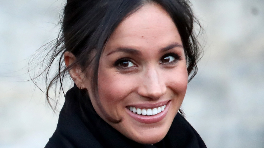 Meghan Markle sonriendo con su cabello recogido