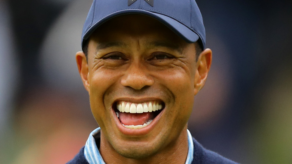 Tiger Woods riendo mientras juega al golf