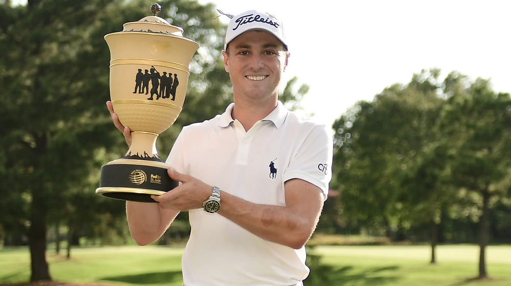 Justin Thomas sosteniendo un gran premio 