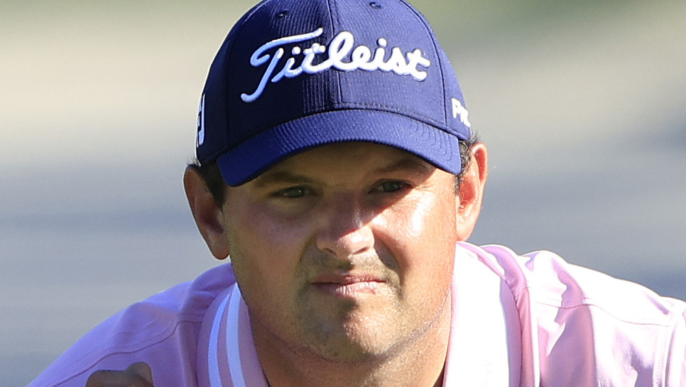 Patrick Reed en cuclillas en el campo de golf