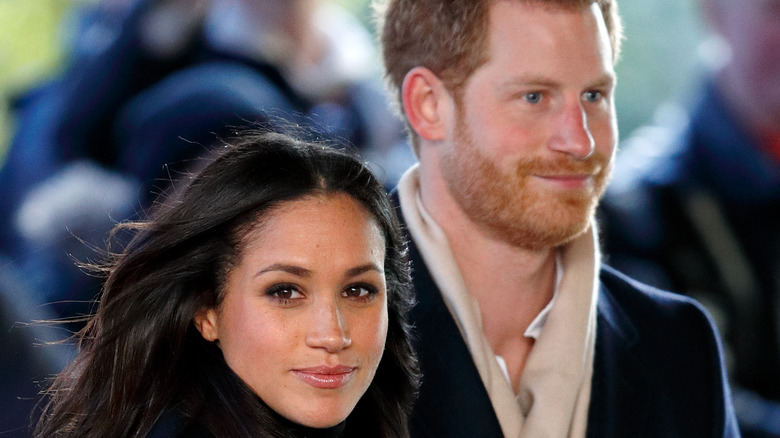 Meghan Markle y el príncipe Harry caminan en el viento