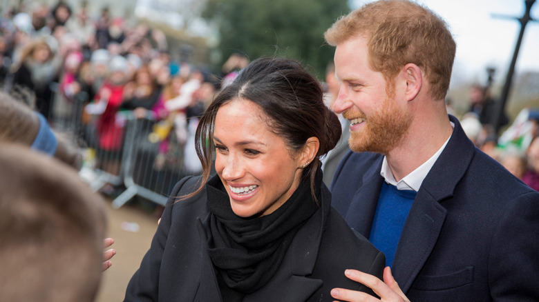 Meghan y Harry se ríen mientras saludan a los fans reales