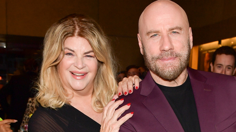 Kirstie Alley sonríe con las manos en el hombro de John Travolta