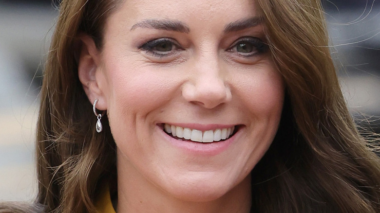 Kate Middleton sonriente cabello castaño y arete de diamantes