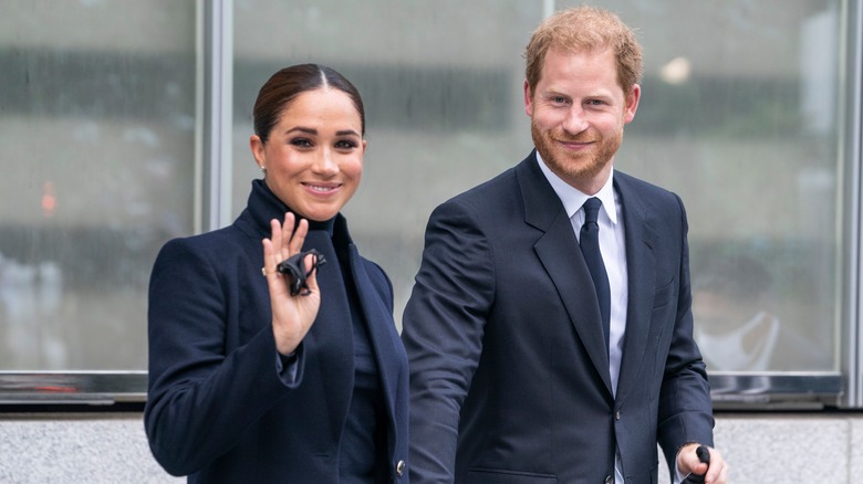 Meghan Markle y el príncipe Harry saludando y sonriendo