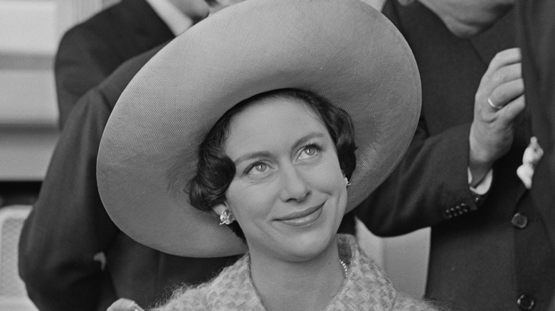 Princess Margaret en un evento con un gran sombrero y sonriendo